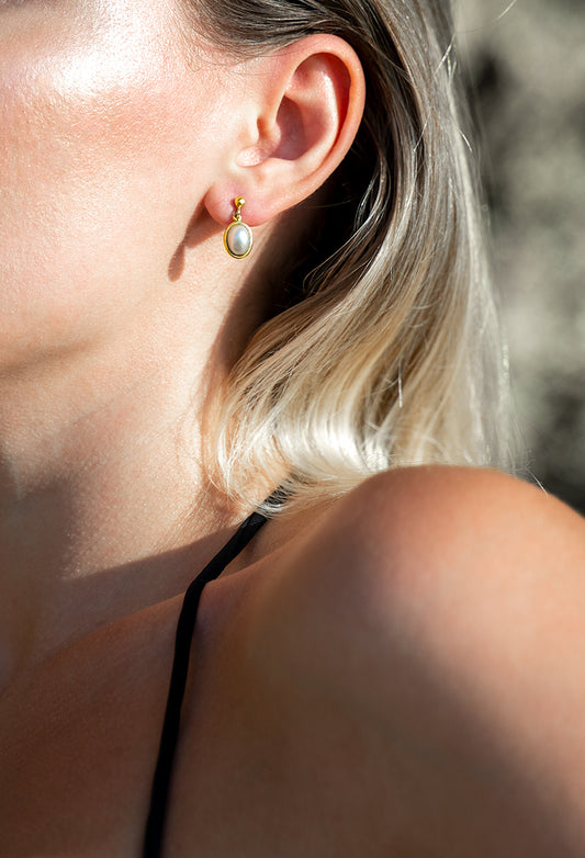 Little golden earrings with a white pearl